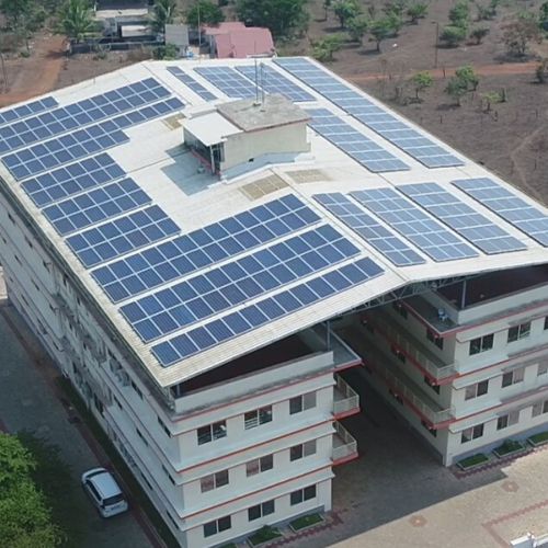 Aerial view of a sprawling building featuring solar panels that blanket the entire roof, captured in an image perfect for a solar blog.